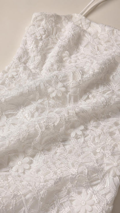 Close-up detail of white 3D floral lace fabric